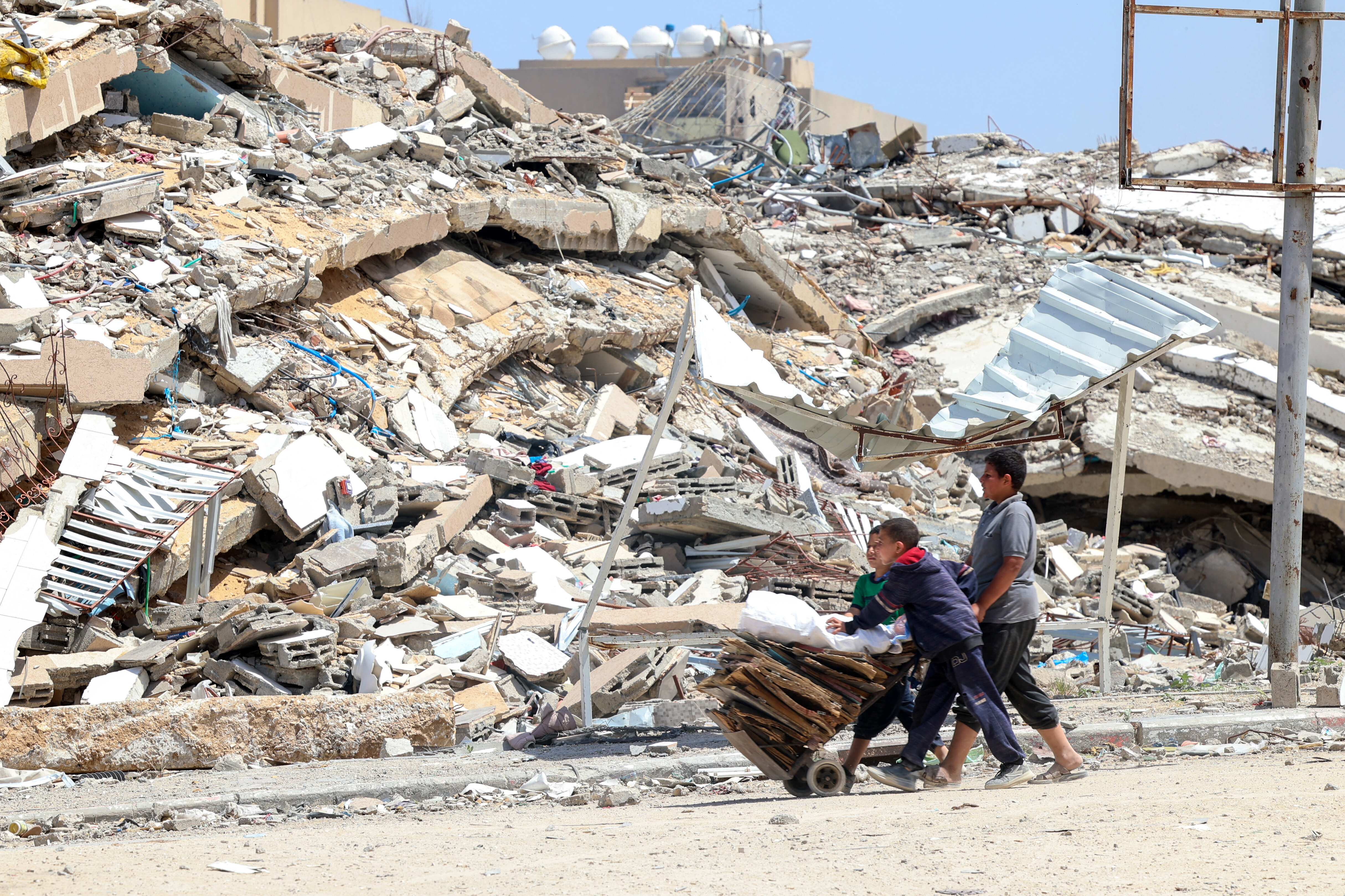 Palestinian youth collect cardboard and wooden pallets in Beit Lahya in the northern Gaza Strip on May 4, 2024, amid the ongoing conflict between Israel and the militant group Hamas. (Photo by AFP via Getty Images)