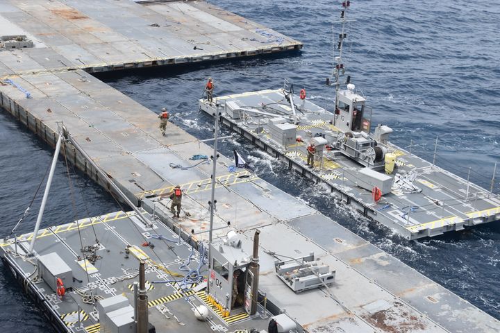 In this image provided by the U.S. Army, soldiers assigned to the 7th Transportation Brigade (Expeditionary) and sailors attached to the MV Roy P. Benavidez assemble the Roll-On, Roll-Off Distribution Facility (RRDF), or floating pier, off the shore of Gaza in the Mediterranean Sea on April 26, 2024. The pier is part of the Army's Joint Logistics Over The Shore (JLOTS) system which provides critical bridging and water access capabilities. (U.S. Army via AP)