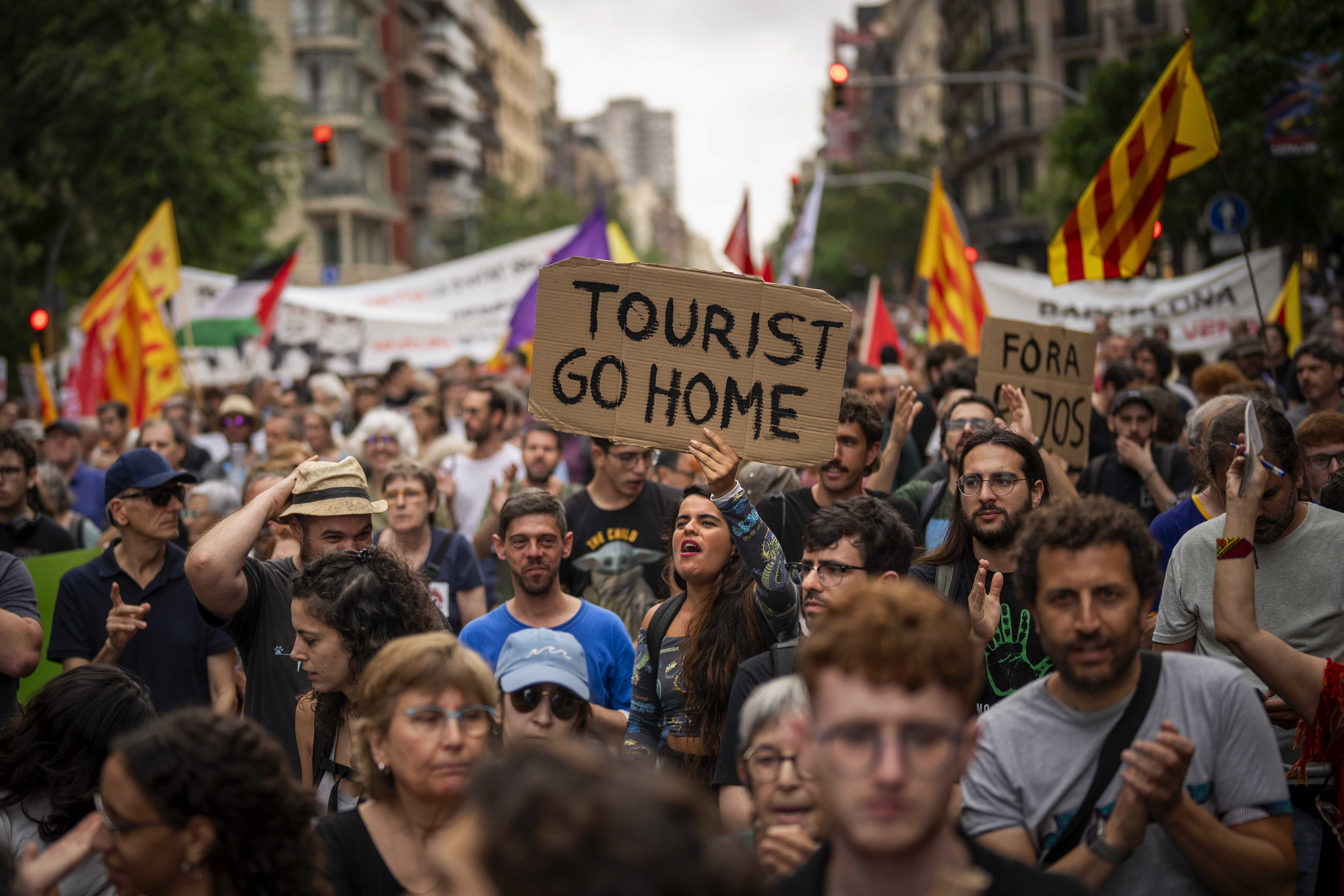 Demonstrators march and shout slogans on June 19 in protest of the Formula One Barcelona Fan Festival in downtown Barcelona. About 500 Barcelona residents protested mass tourism at an exhibition of the Formula One cars.