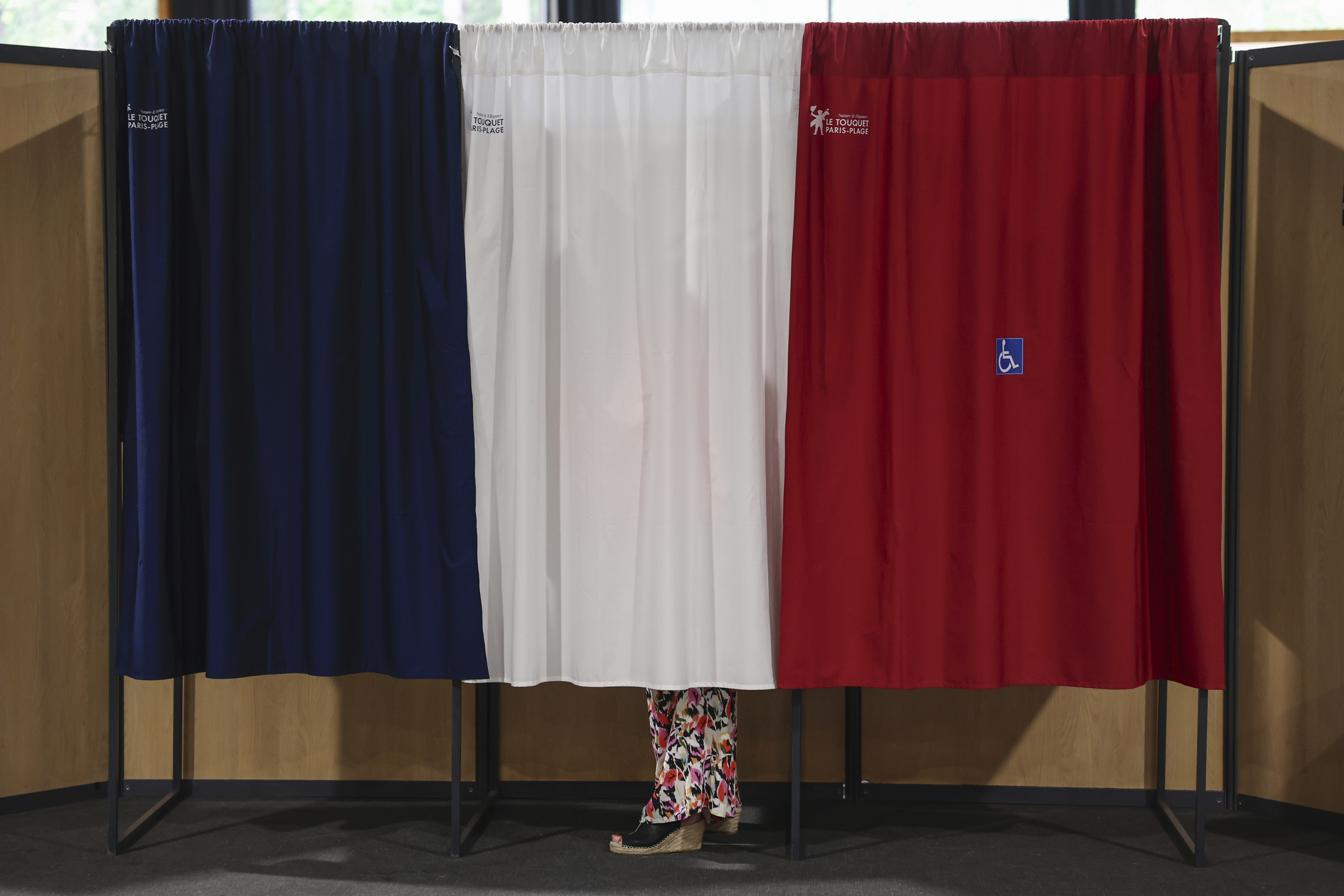 A voter stands in the polling booth during the second round of the legislative elections in Le Touquet-Paris-Plage, northern France, Sunday July 7 2024. (Mohammed Badra, Pool via AP)