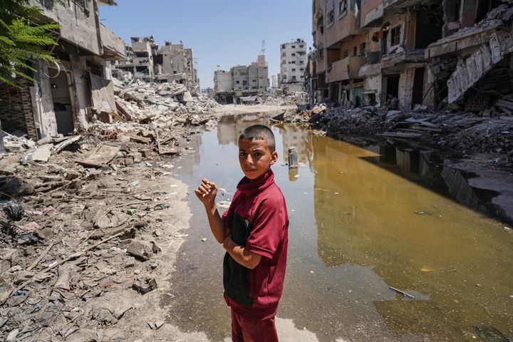 A Palestinian boy looks over as he stands on the rubble of buildings destroyed by the Israeli army, on the edge of stagnant water in Khan Younis in the southern Gaza Strip on July 19, 2024. The Israeli Health Ministry said that Gaza sewage samples tested in its lab detected poliovirus type 2, a finding similar to that of the World Health Organization.