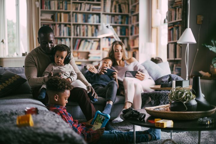 A family using devices in their living room