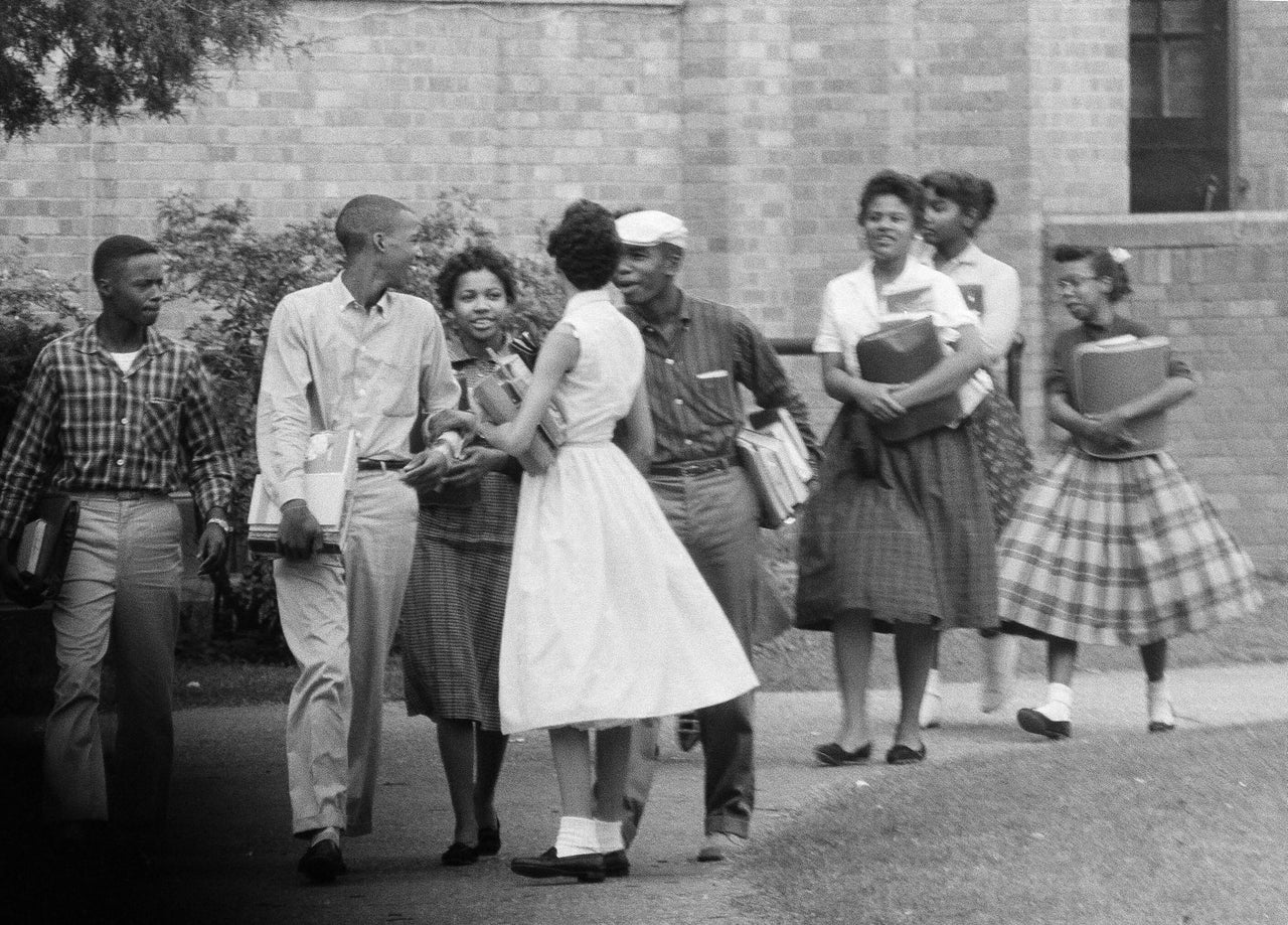 The first Black students to enroll at Central High School in Little Rock, Arkansas, leave the building and walk toward a waiting Army station wagon following their classes.